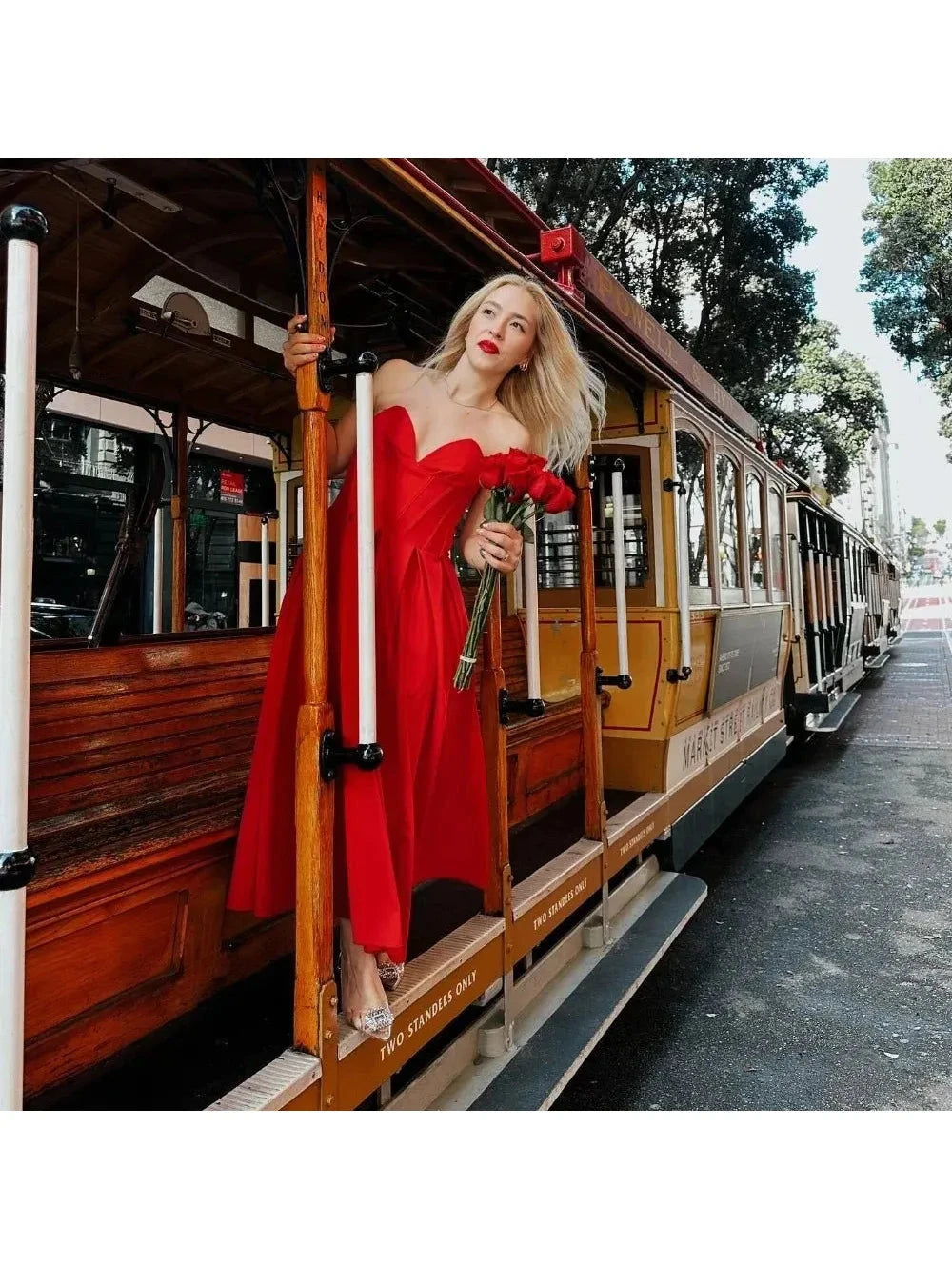 Red Adaline strapless pleated midi dress by Lumina Vancouver, shown on a model with a close-up of the sleek, flowing fabric.