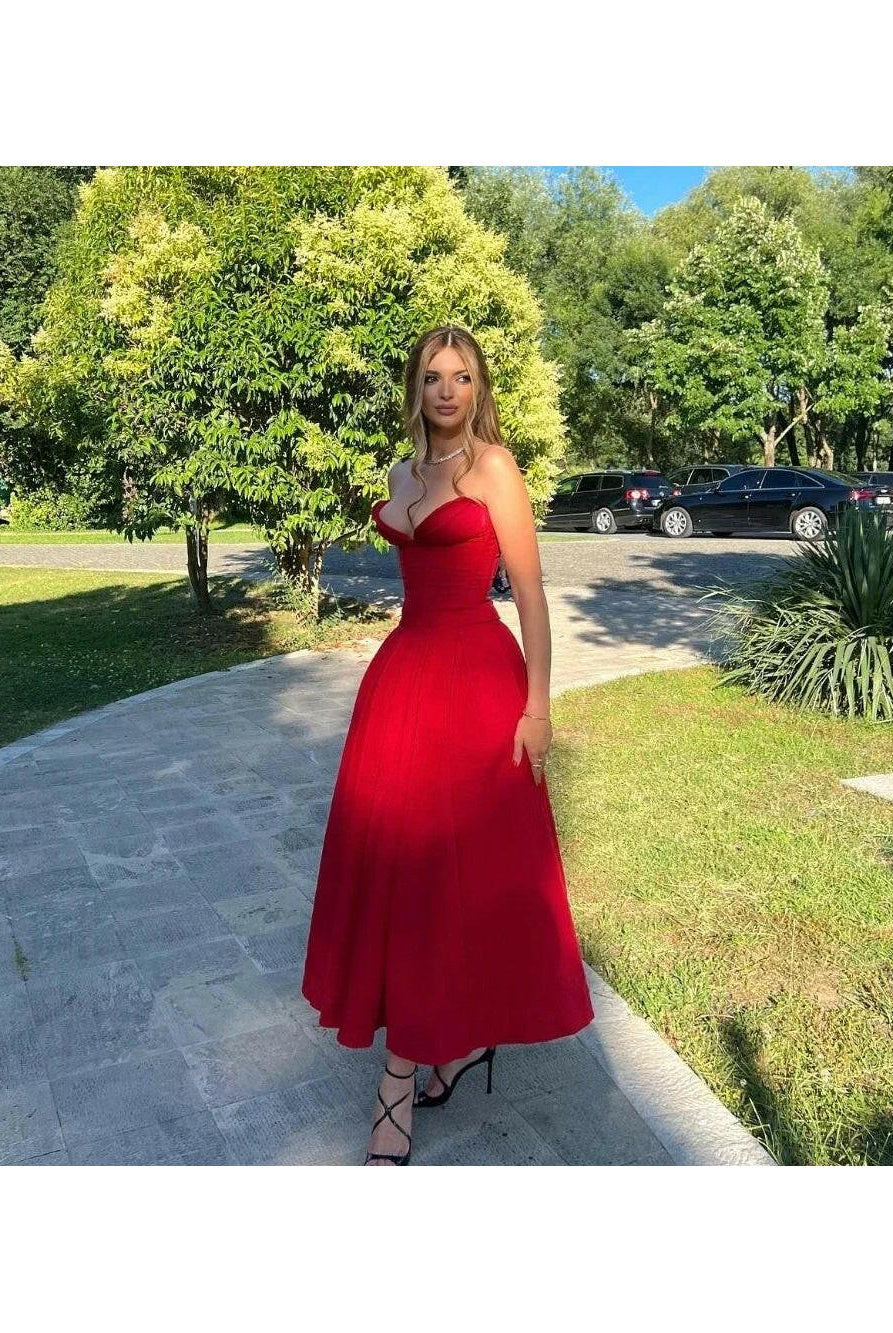 Red Adaline strapless pleated midi dress by Lumina Wear, featuring a sleek design and flowing pleats.