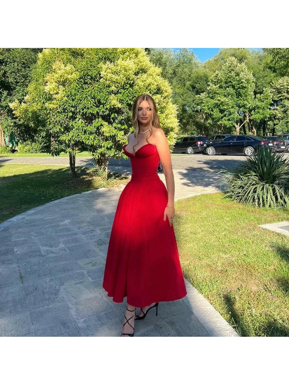 Red Adaline strapless pleated midi dress by Lumina Vancouver, showcasing a sleek design with a fitted bodice and flowing skirt.