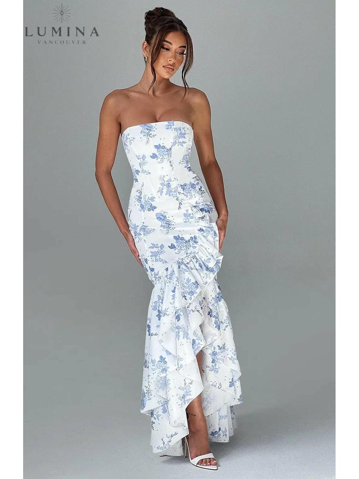 Blue floral sleeveless slit ruffle maxi dress by Lumina Wear, perfect for wedding guests, showcasing elegant design and flowing fabric.