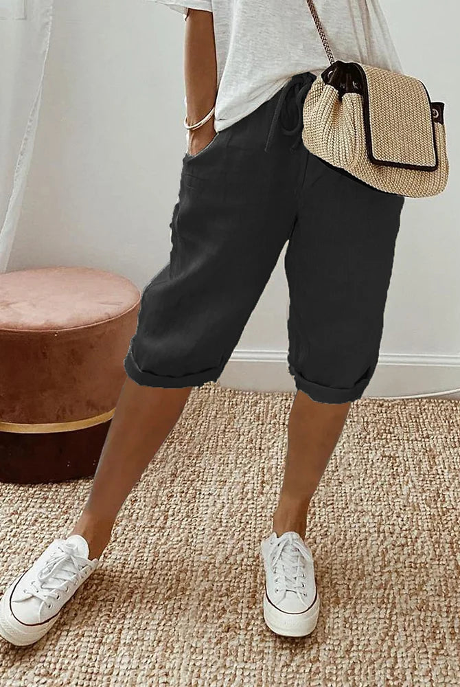 Beige linen blend shorts with adjustable waist from Lumina Wear, relaxed fit, shown on a model with green background.
