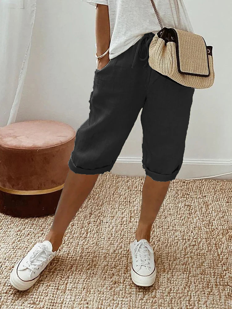 Beige linen blend shorts with adjustable waist from Lumina Wear, relaxed fit, shown on a model with green background.