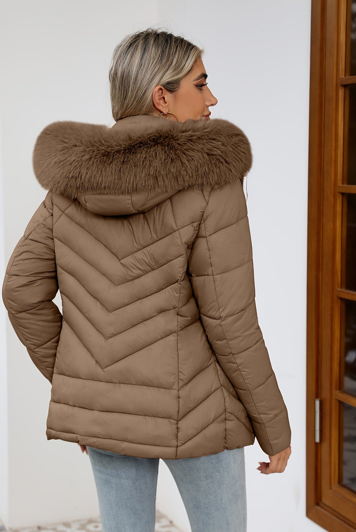 Women's Ruby quilted puffer jacket with faux-fur hood by Lumina Wear in black, showcasing cozy quilted design and plush fur trim.