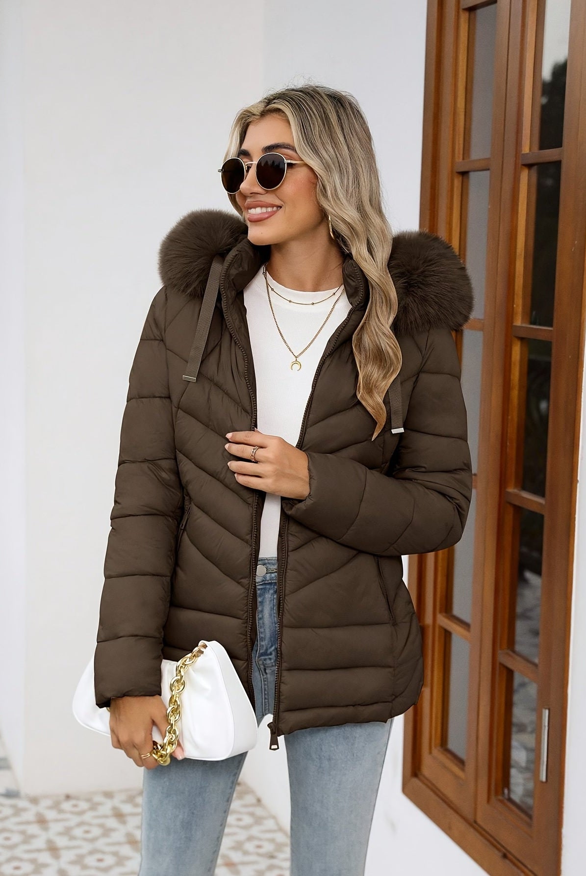 Black women's Ruby quilted puffer jacket with faux-fur hood by Lumina Wear, showcasing cozy insulation and stylish design.