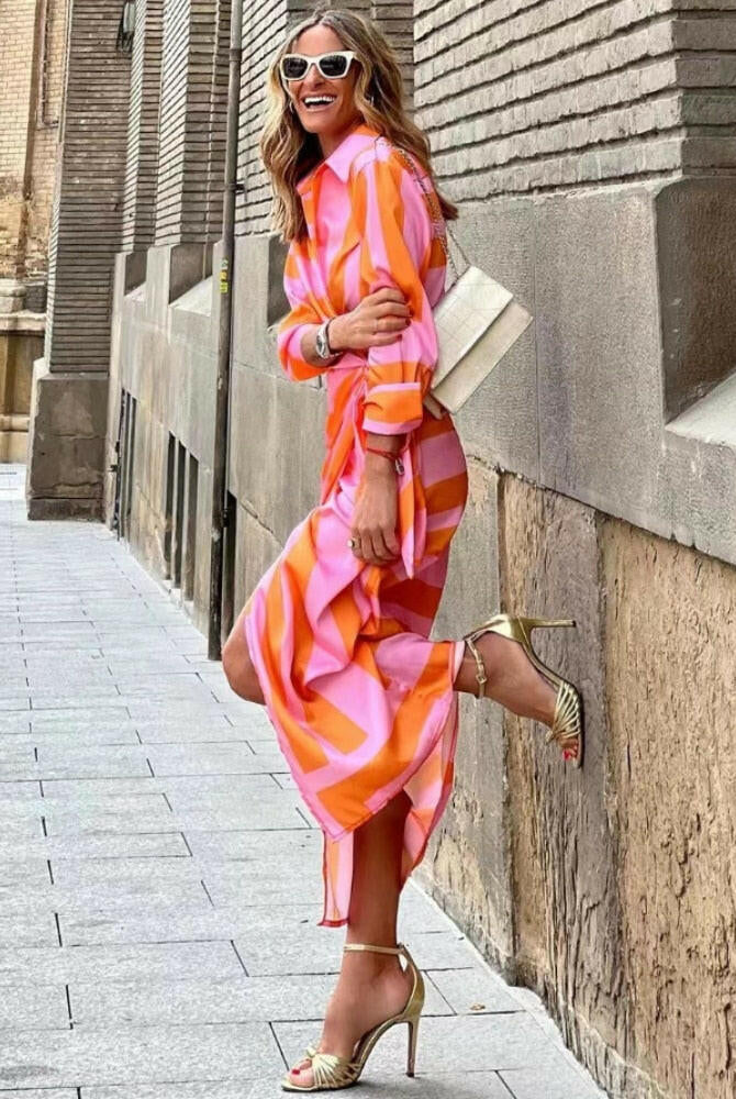 Orange and pink printed wrap dress by Lumina Wear, featuring a stylish design and flowing fabric, perfect for casual or dressy occasions.