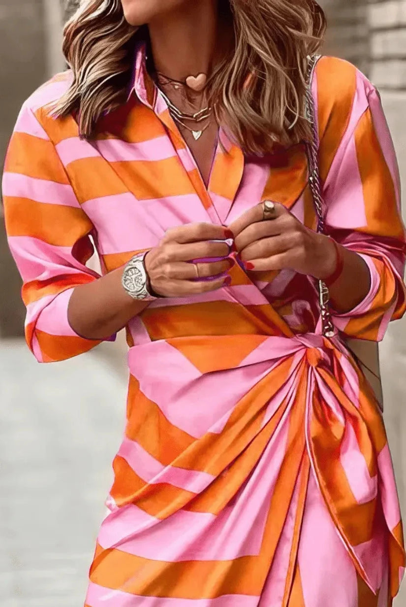 Lumina Wear Solana printed wrap dress in vibrant orange and pink, featuring a stylish silhouette perfect for casual or dressy occasions.
