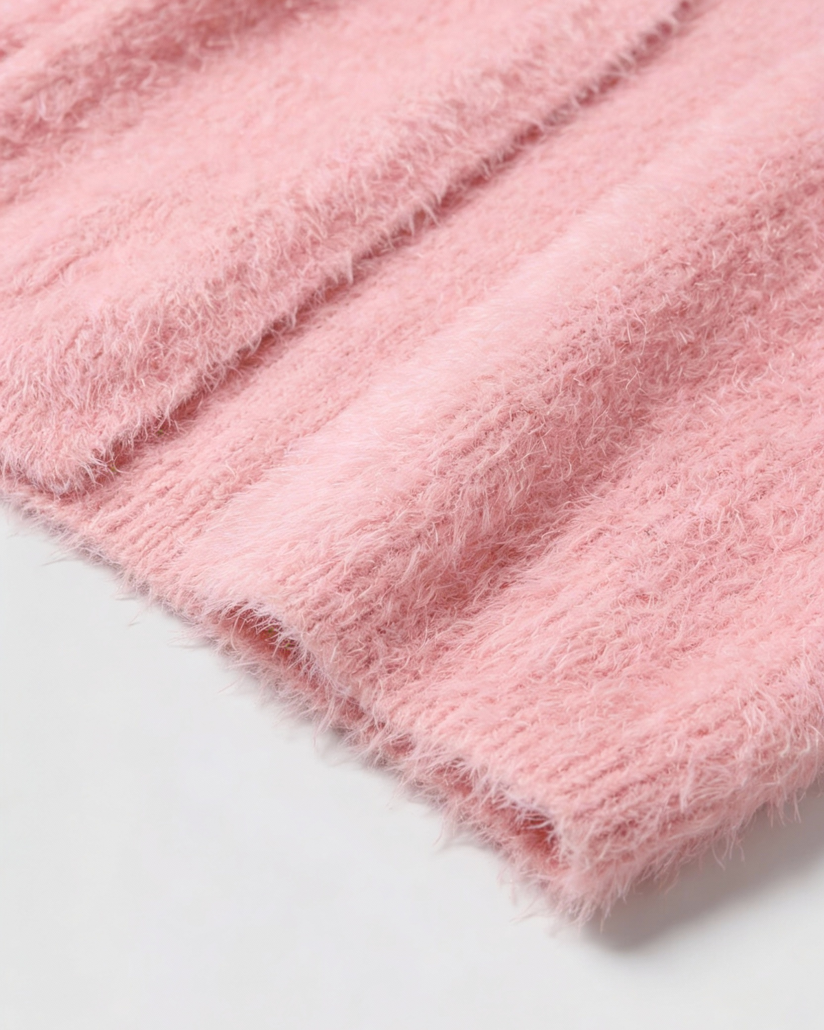 Pink knit cardigan from Lumina Wear, styled casually with a relaxed fit and cozy texture, perfect for versatile layering.