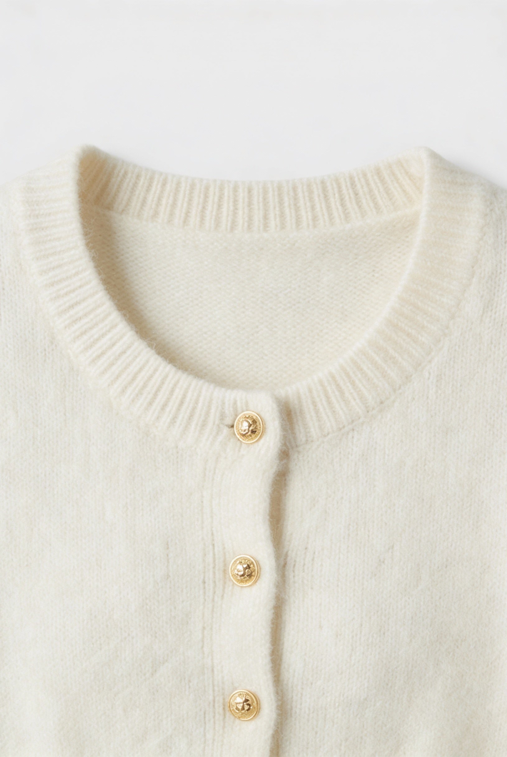 Sophia white cardigan sweater with ruffle details by Lumina Wear, cozy knit with stylish ruffle accents, perfect for casual wear.