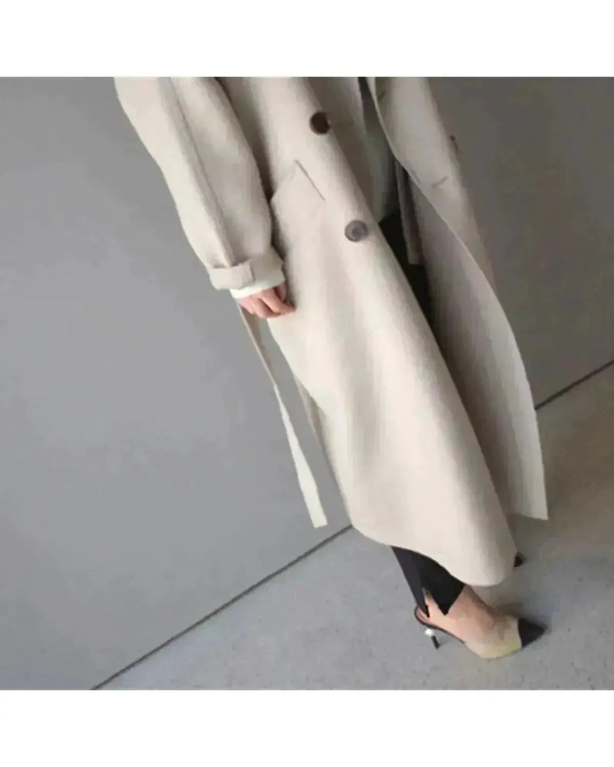 Beige Sophie long coat for women by Lumina Wear, featuring elegant design and tailored fit, shown hanging on a rack.