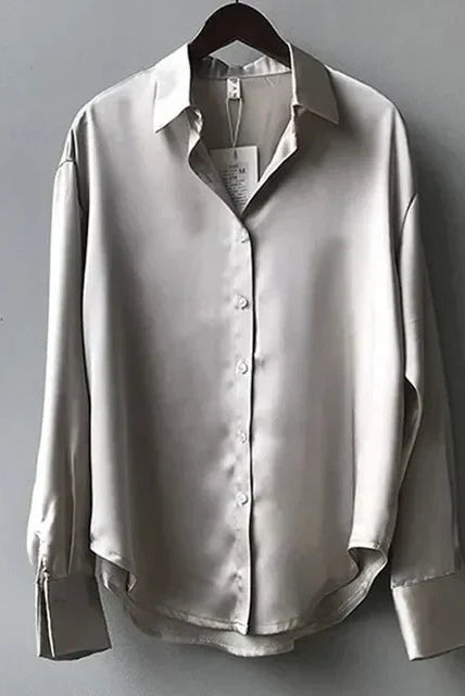 Green satin blouse by Lumina Wear featuring a classic button-down design, styled with long sleeves and elegant detailing.
