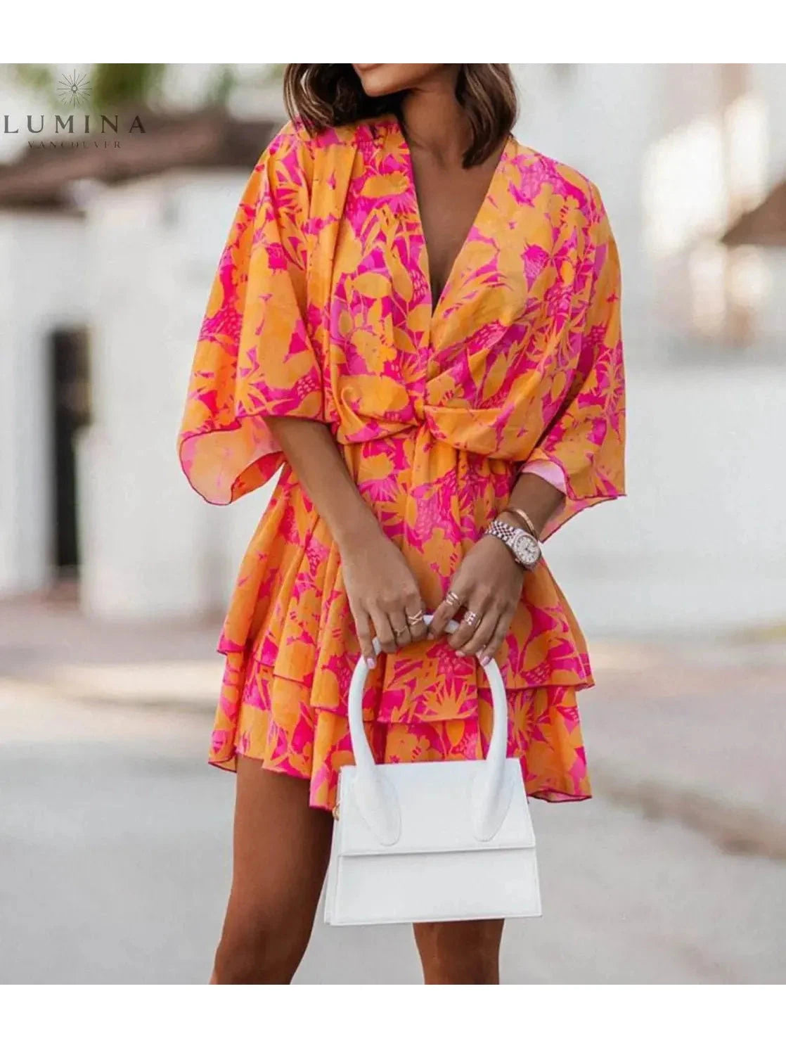 Valeria bohemian floral mini dress in orange and pink from Lumina Vancouver's summer dress collection, featuring a flowy, casual style.