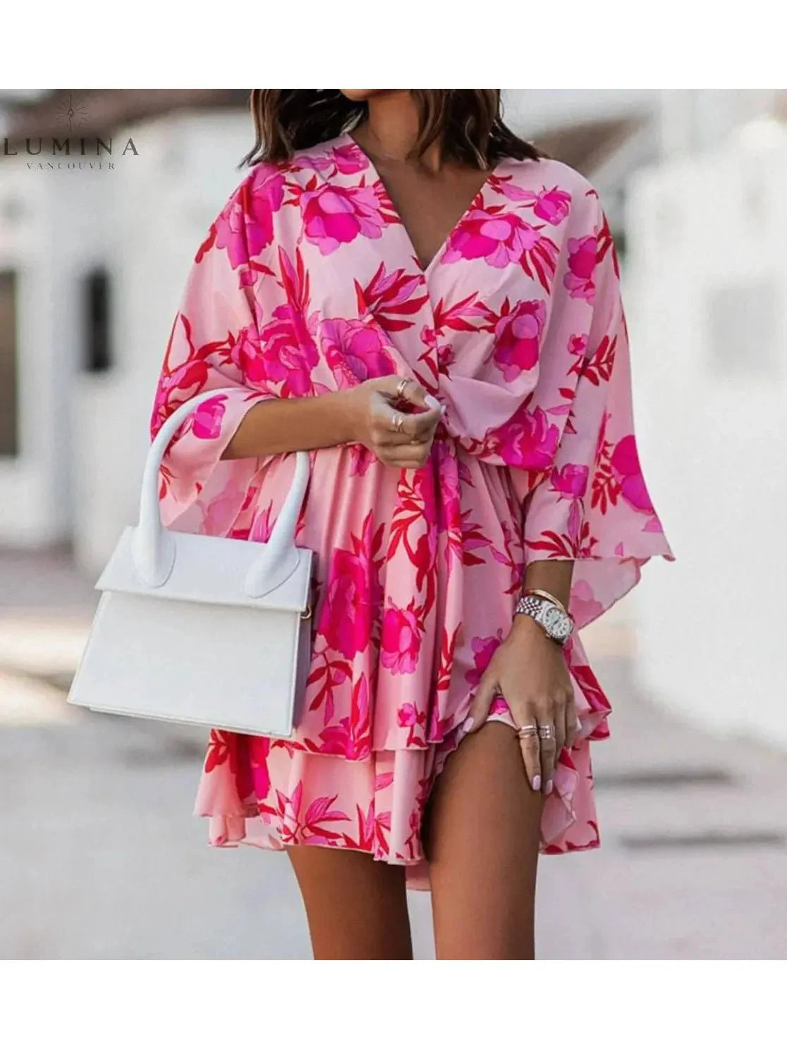Valeria bohemian floral mini dress in orange and pink from Lumina Vancouver's summer dress collection, featuring a casual, flowy design.