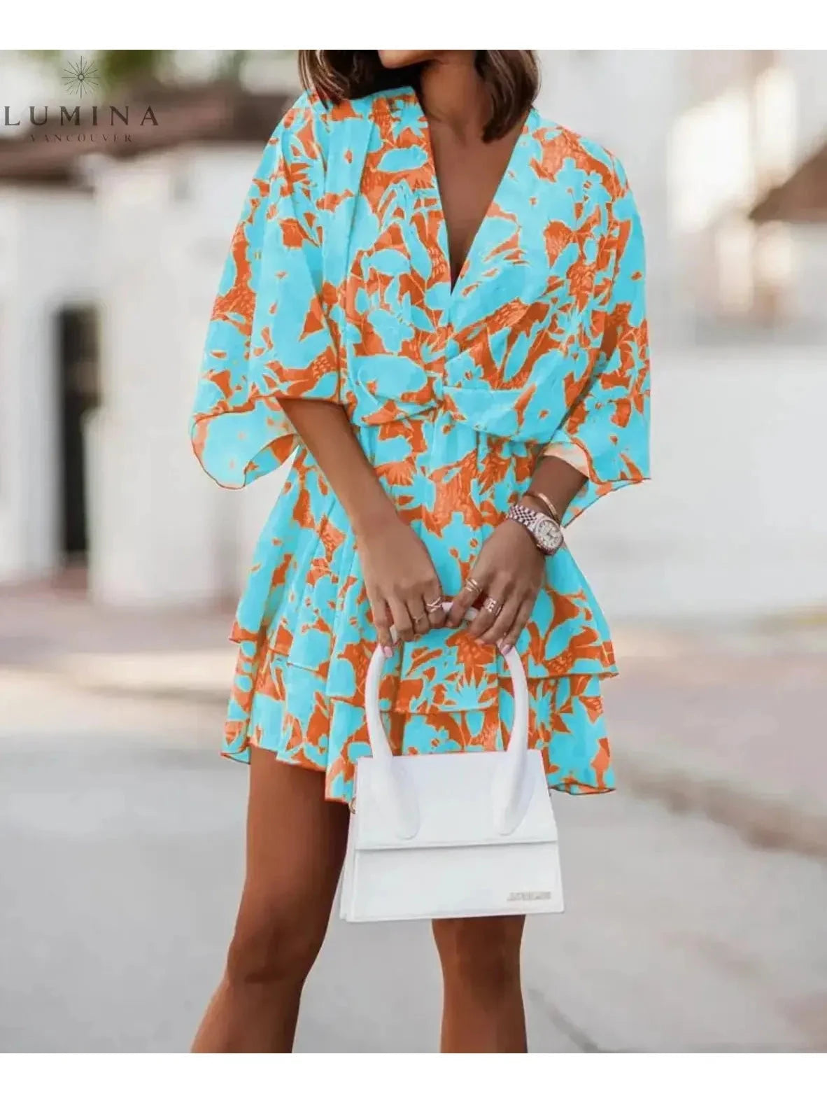 Valeria bohemian floral mini dress in orange and pink from Lumina Vancouver's summer dress collection, featuring a vibrant, flowy design.