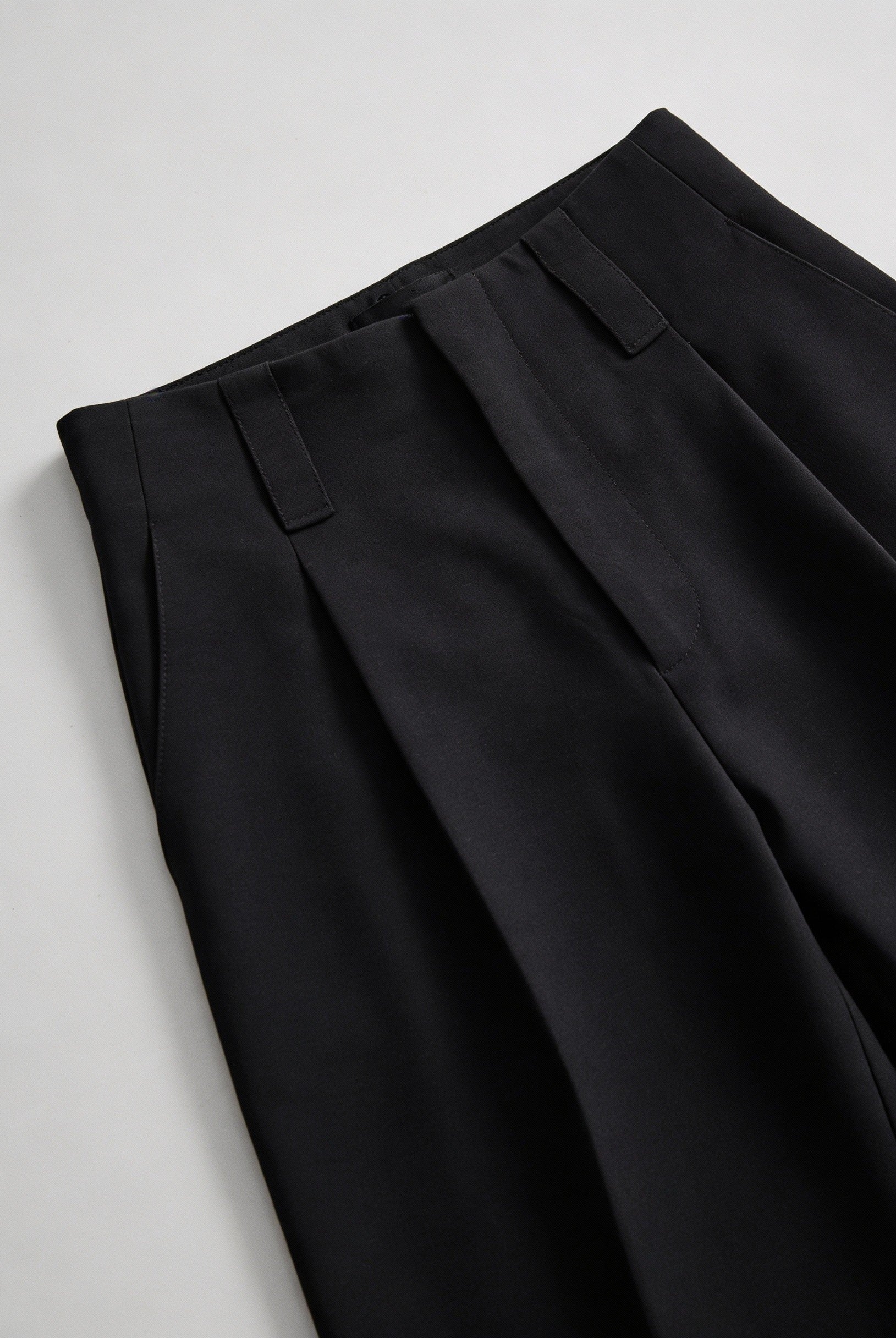 Elegant black high-waisted women's trousers with pleats by Lumina Wear, featuring a tailored fit and classic design.