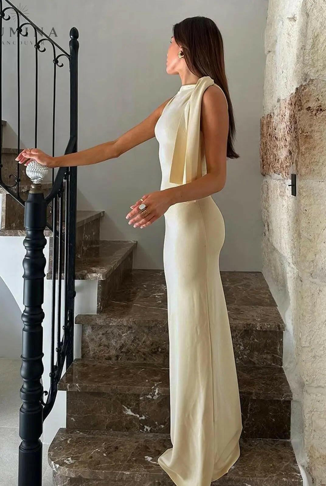 Off-white Yasmine knotted maxi dress by Lumina Wear, flowing fabric with a tied waist, showcased on a model.