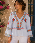 Lumina Wear Penelope bohemian embroidered summer blouse with V-neck, featuring colorful floral embroidery and lightweight fabric.