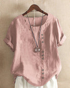 Light beige Beatrice summer blouse by Lumina Wear featuring relaxed fit and button details, shown on a model.