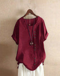 Light beige Beatrice summer blouse by Lumina Wear with relaxed fit and button details, displayed on a hanger.