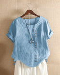 Light beige Beatrice summer blouse by Lumina Wear featuring relaxed fit and button details, displayed on a hanger.