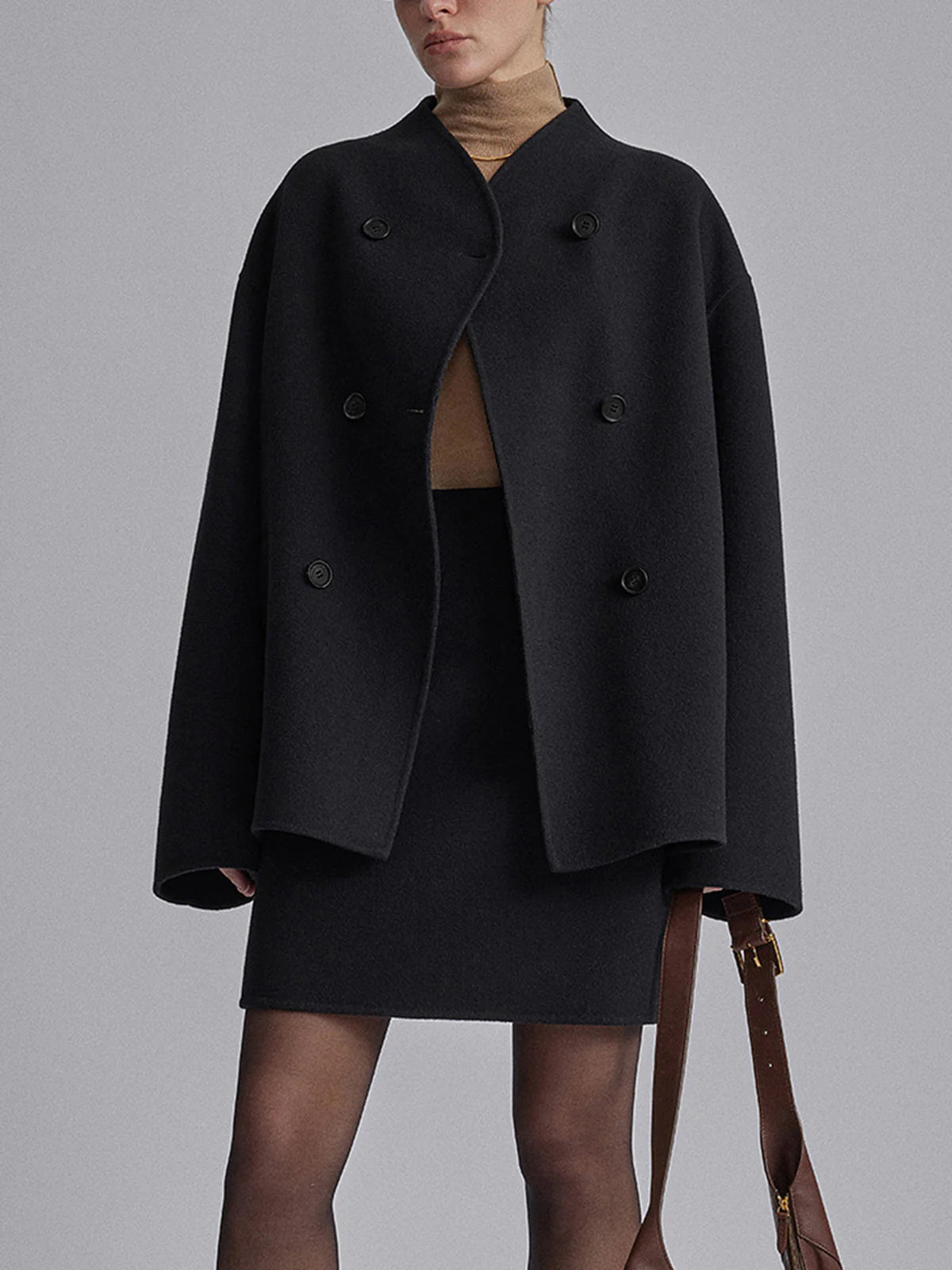 Black Charlene double-breasted peacoat with stand collar by Lumina Wear, shown on a hanger with front buttons and tailored fit.