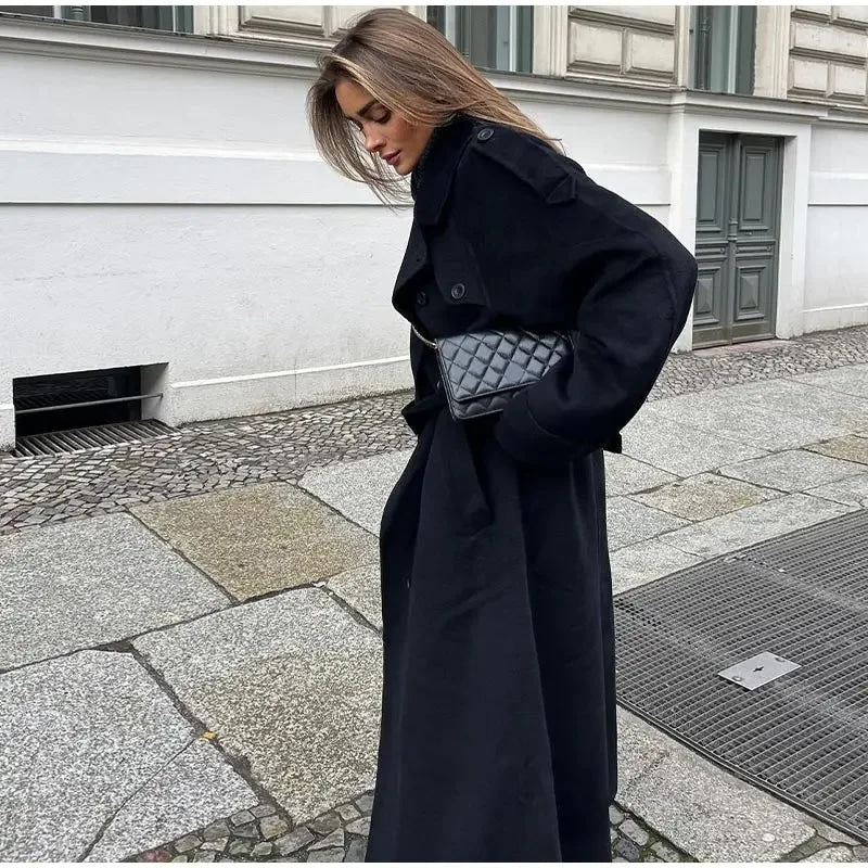Black double-breasted trench coat with belted waist from Lumina Wear, shown on a model with classic lapels and stylish silhouette.