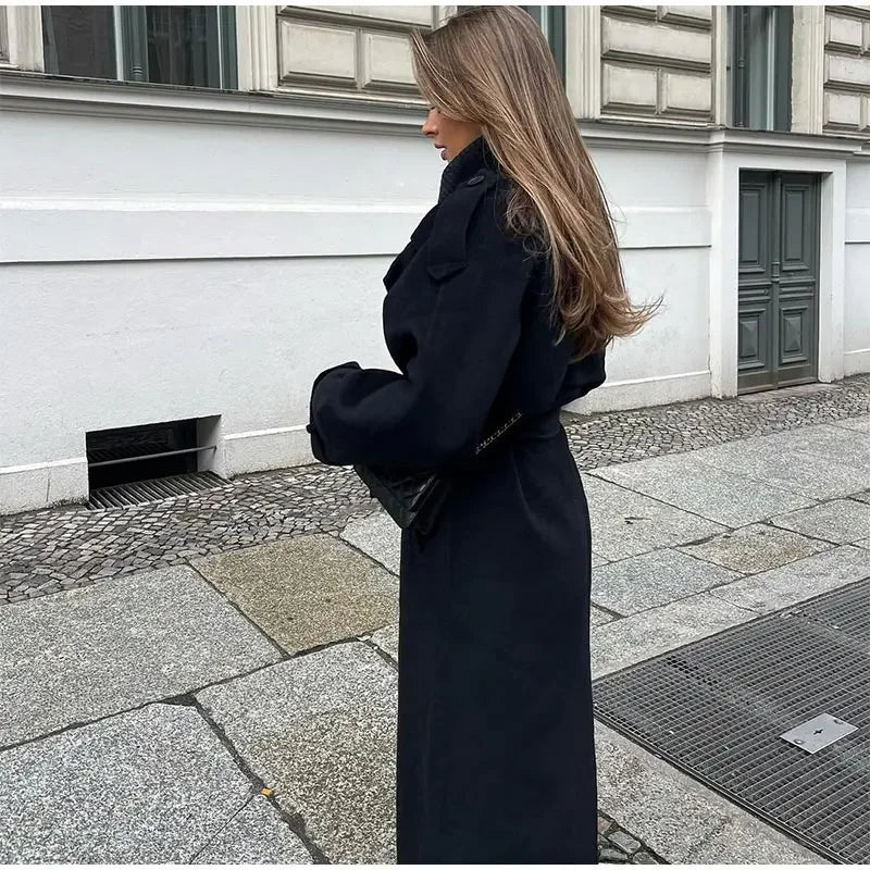 Black double-breasted trench coat with belted waist from Lumina Wear, shown on a model with classic lapels and long sleeves.