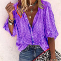 Brightly printed casual blouse by Lumina Wear featuring a button front and vibrant design, shown on a model.
