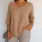 Cream-colored Lumina Wear Clara relaxed V-neck sweater with minimalist design, soft knit fabric, and comfortable fit.