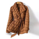 Lumina Wear Elise tailored geometric down puffer jacket with belted waist, featuring a modern design and quilted texture.