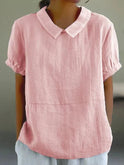Linen blouse by Lumina Wear featuring a Peter Pan collar, displayed on a hanger with soft fabric texture and classic design.