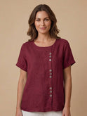 Light beige Lumina Wear Grace linen blouse with relaxed fit and button detail, displayed on a mannequin.