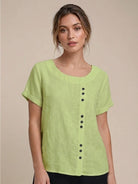 Lumina Wear Grace linen blouse with relaxed fit and button detail, showcased on a model in a casual setting.