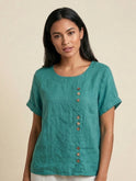 Light beige Lumina Wear Grace linen blouse with relaxed fit and button details, shown on a model, casual and comfortable style.