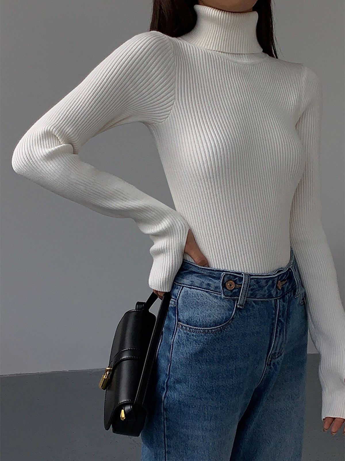 Black Lumina Wear Hailey minimalist turtleneck top, showcasing a sleek winter-appropriate design with a close-up of the fabric and neckline.