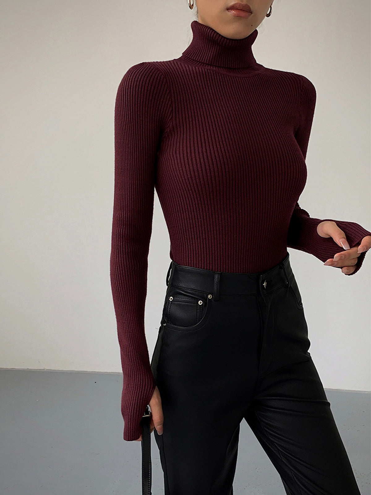 Lumina Wear Hailey sleek minimalist turtleneck top for winter, shown in a close-up of the fitted black turtleneck fabric.