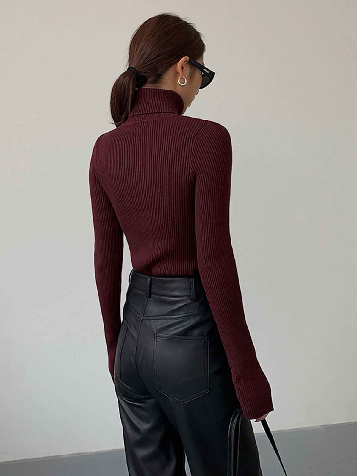 Lumina Wear Hailey sleek minimalist turtleneck top in winter black, showing a close-up of the fitted, smooth fabric and high neckline.