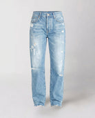 Distressed mid-rise straight leg jeans with frayed hem from Lumina Wear's Isabella collection, shown in a close-up view.