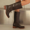Black knee-high boots with stacked heels from Lumina Wear, featuring a sleek, elegant design and smooth leather finish.