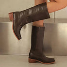 Elegant black knee-high boots with stacked heel from Lumina Wear, featuring sleek leather and stylish design.
