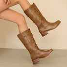 Elegant black knee-high boots with stacked heels from Lumina Wear, featuring a sleek design and stylish silhouette.