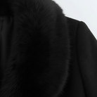 Elegant long wool coat with fur collar by Lumina Wear, featuring a stylish silhouette and luxurious detailing.