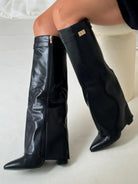 Black knee-high boots for women with pointed toes and side zipper from Lumina Wear's Isabella collection.