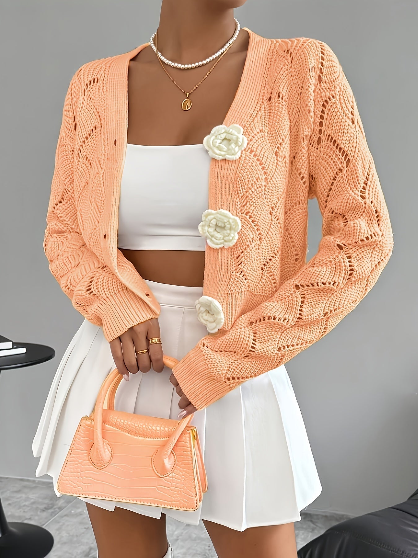 White crochet women's cardigan with floral buttons from Lumina Wear, featuring elegant and delicate knit details.