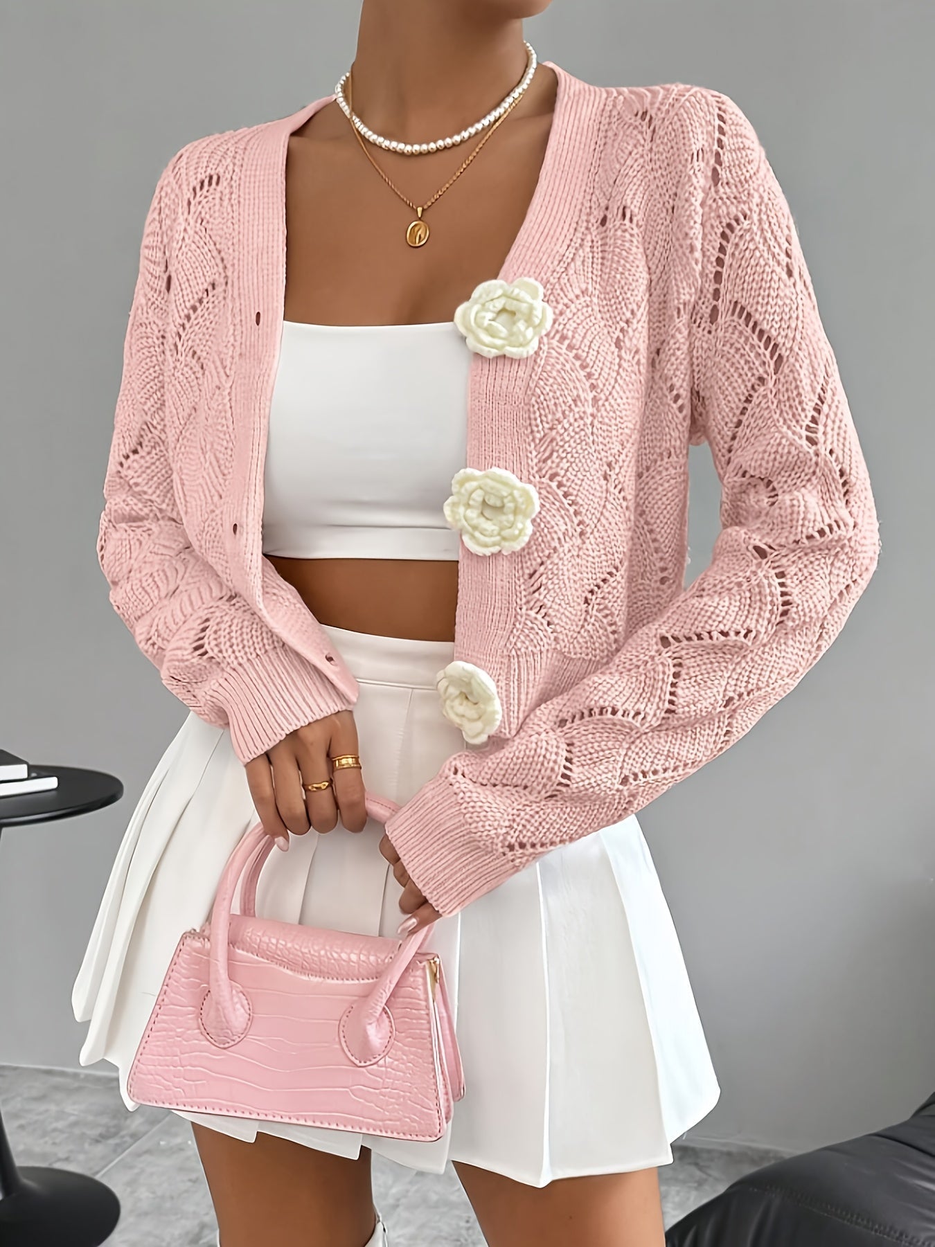 Elegant white crochet women's cardigan with floral buttons from Lumina Wear, featuring intricate knit pattern and charming button details.