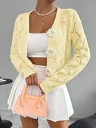 White crochet women's cardigan with floral buttons from Lumina Wear, featuring an elegant design and delicate knit texture.