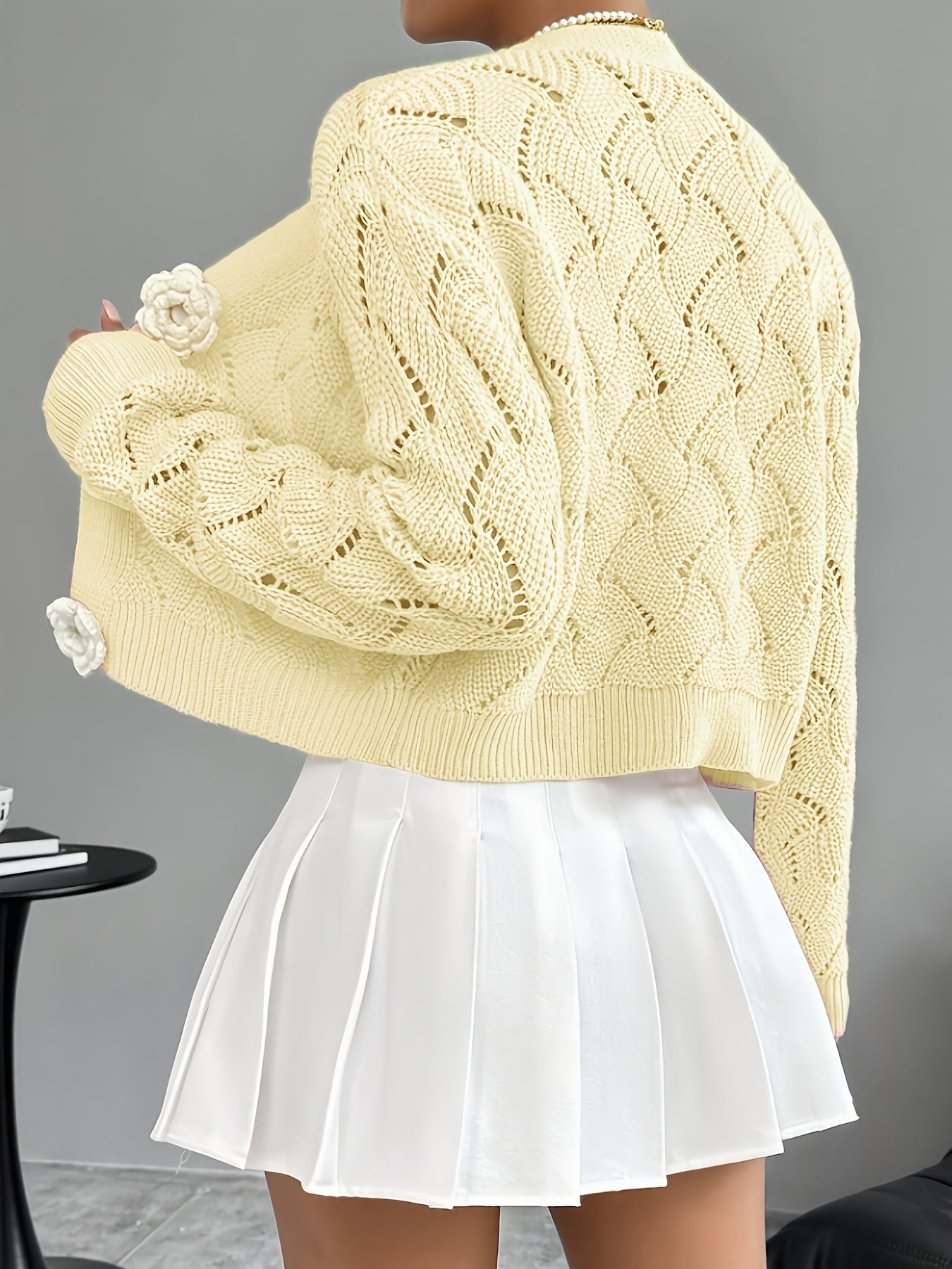 White crochet cardigan for women by Lumina Wear featuring floral buttons and elegant design.
