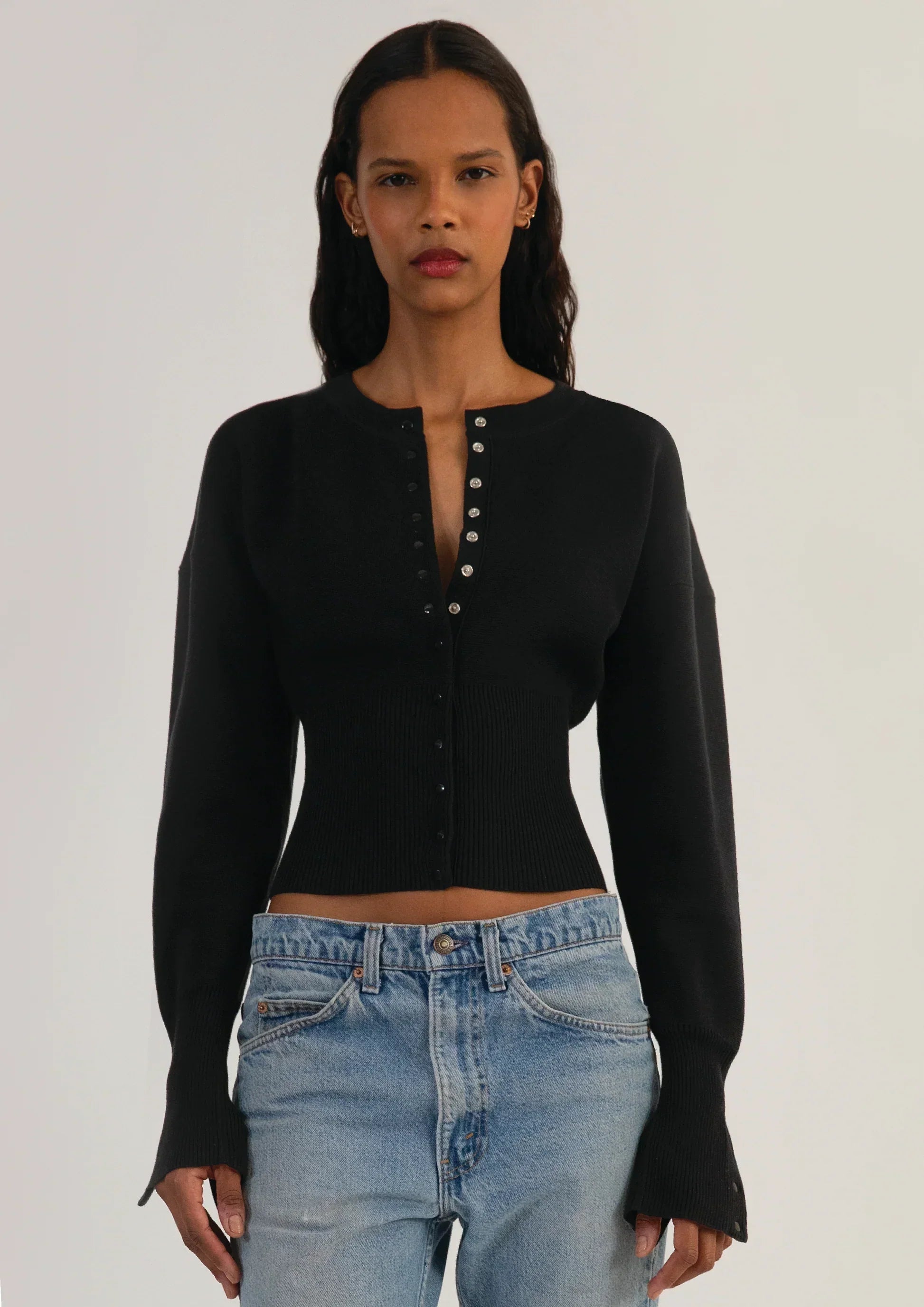 Fitted ribbed cropped cardigan with button closure in neutral color from Lumina Wear's Isabella collection, styled on a model