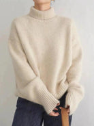 Black oversized turtleneck sweater by Lumina Wear, relaxed fit, cozy knit, worn by a model with long hair.