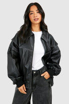 Isabella oversized black vegan leather bomber jacket with ribbed cuffs from Lumina Wear, shown on a hanger.