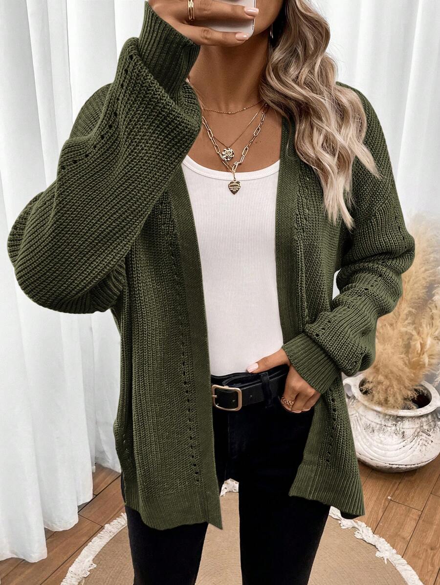 Black pointelle knit women's cardigan sweater with side split hem by Lumina Wear, styled with long sleeves and open front.